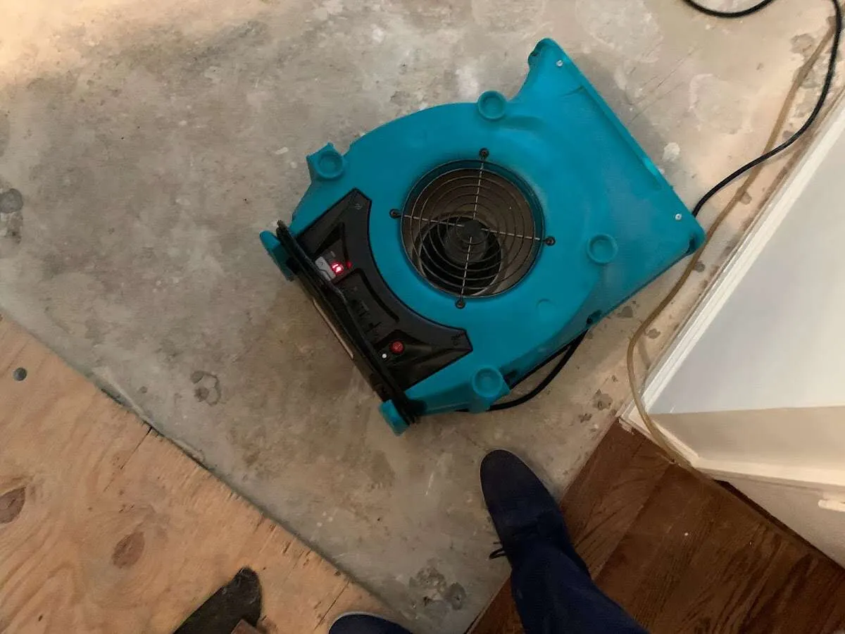 Air mover drying subfloor during Commercial Water Damage Restoration in The Crossings